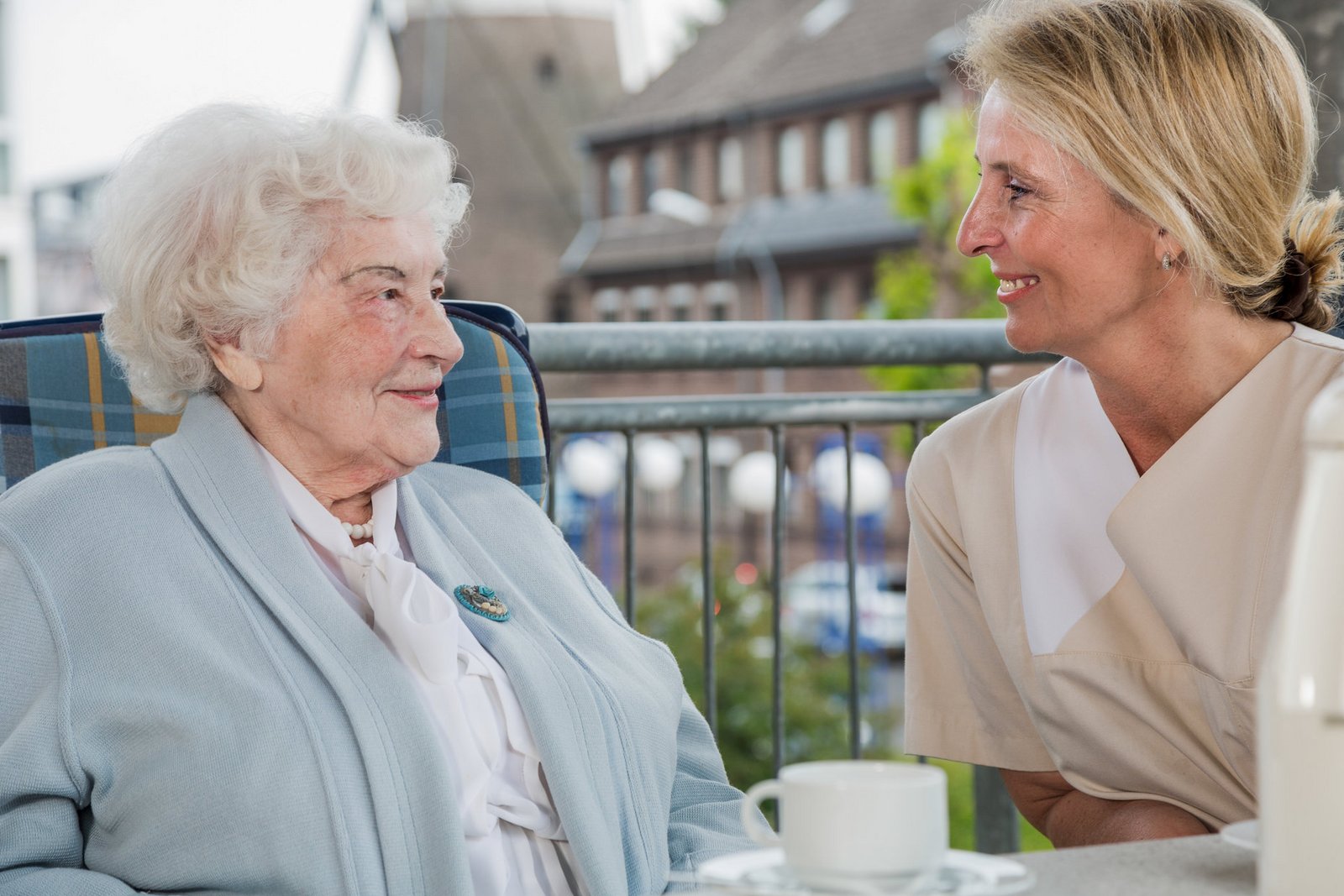 Plegerin und ältere Dame im Gespräch am Balkon Pflegerin und ältere Dame im Gespräch am Balkon